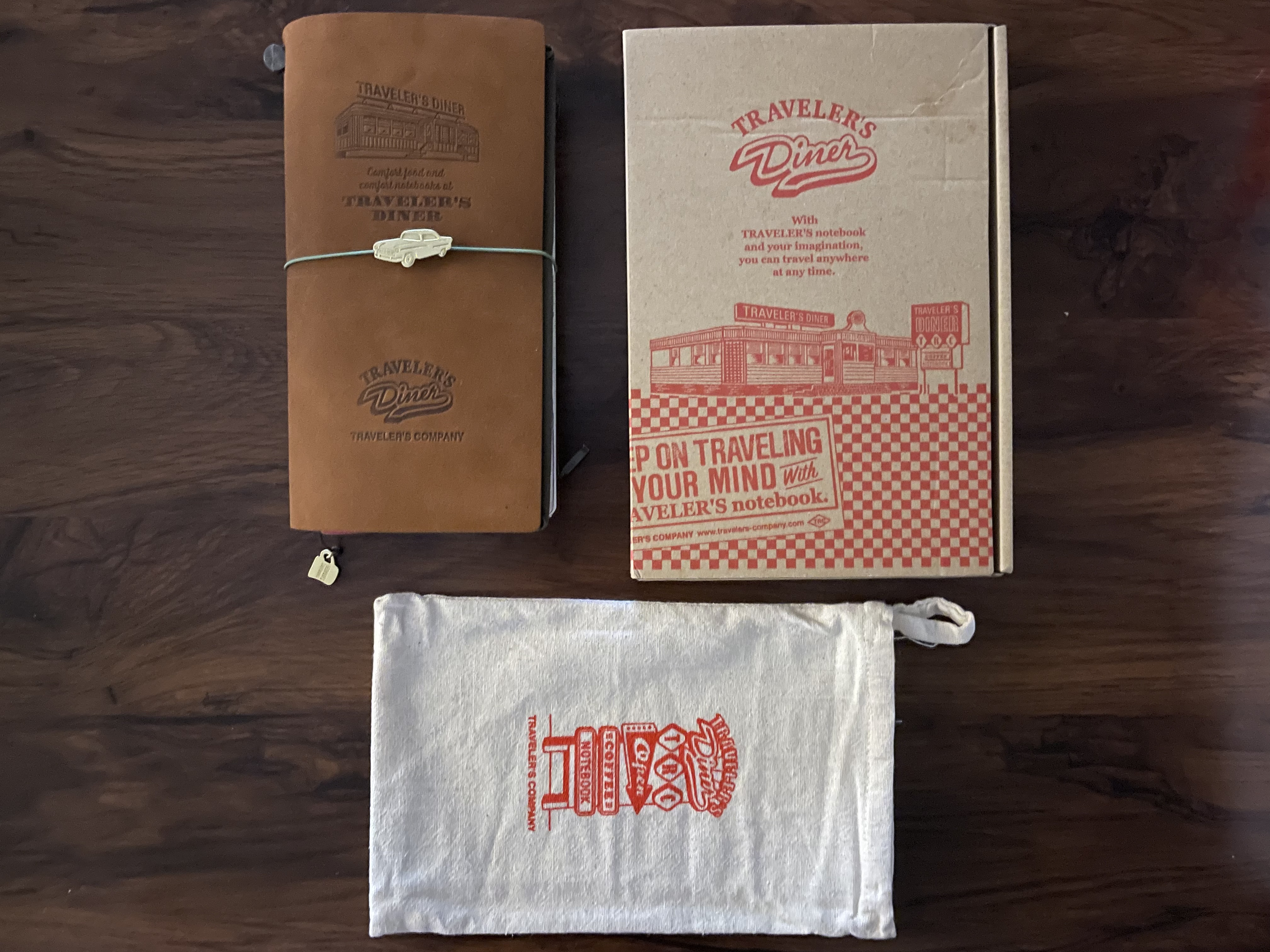 another picture of the diner traveler's notebook, this time with the two aforementioned charms attached to it: the car charm is attached to the elastic, while the coffee charm is attached to the bookmark string
